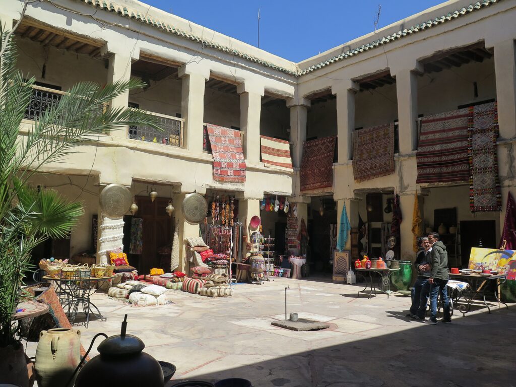 A Marrakech foundouk with people and artisans